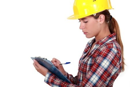 A woman with a clipboard thinking about Construction High Risk Strategy from WorkSafeBC