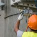 hvac technician checking capacitor on air conditioner