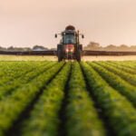 Lone worker in a tractor spraying in a Canadian field