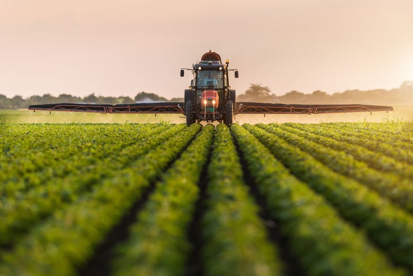 Lone worker in a tractor spraying in a Canadian field