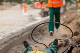 worker running towards a man hurt by hazard when lone working